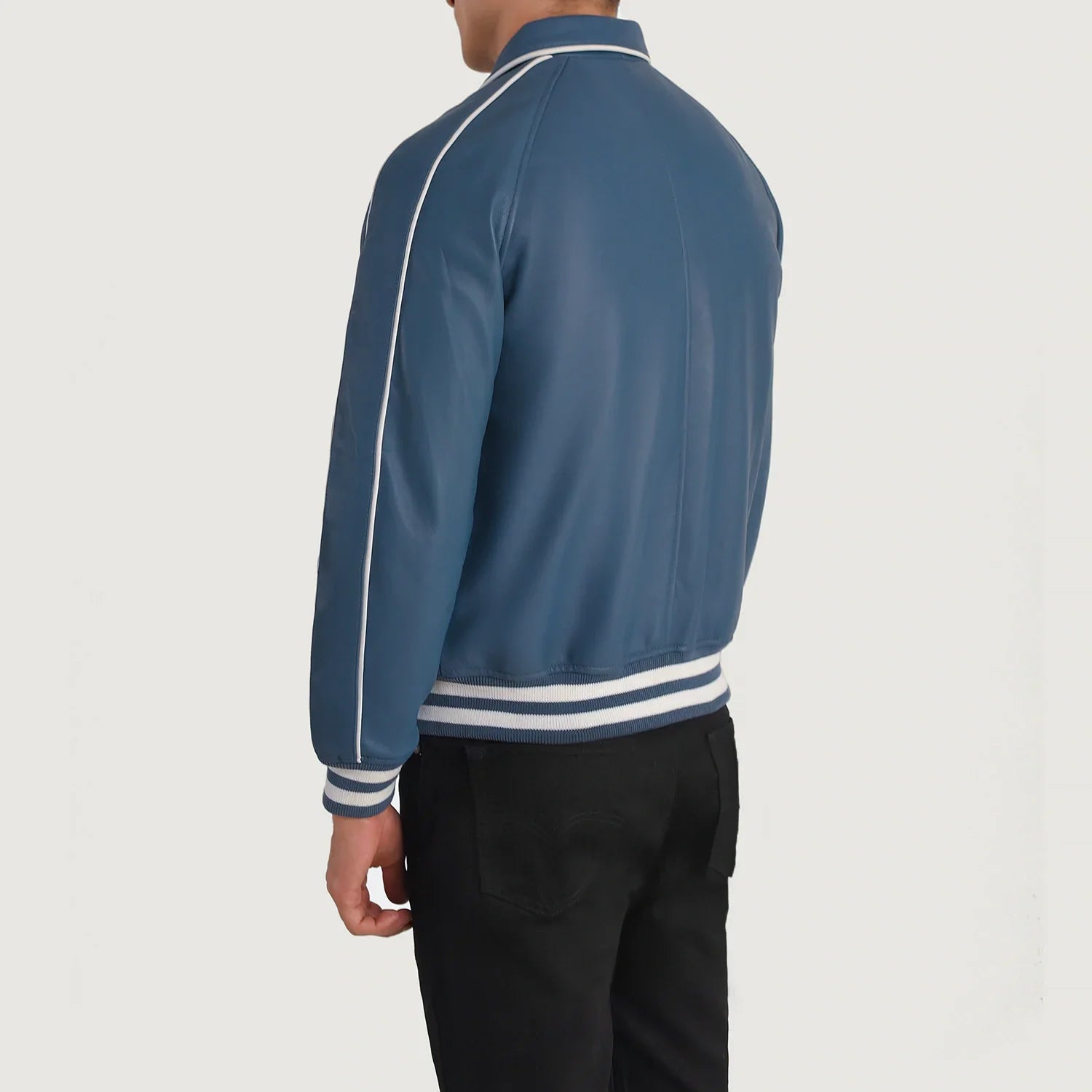 Back view of man wearing blue leather varsity jacket with white stripes on sleeves and waistband