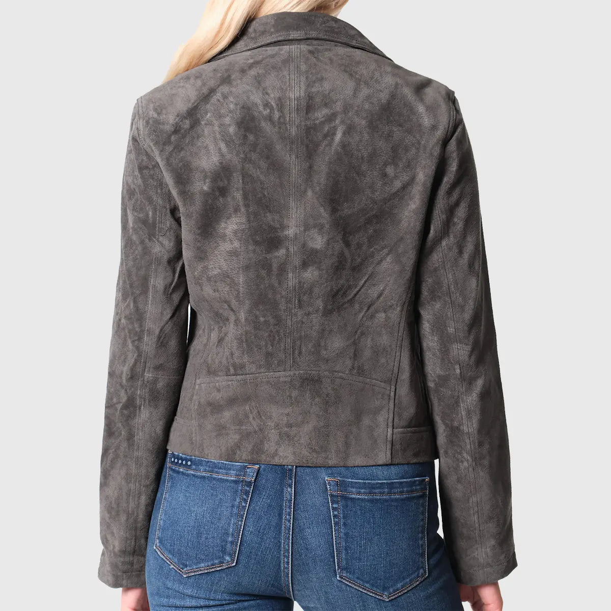 Back view of a woman wearing a brown suede biker jacket in dark gray tone paired with blue jeans