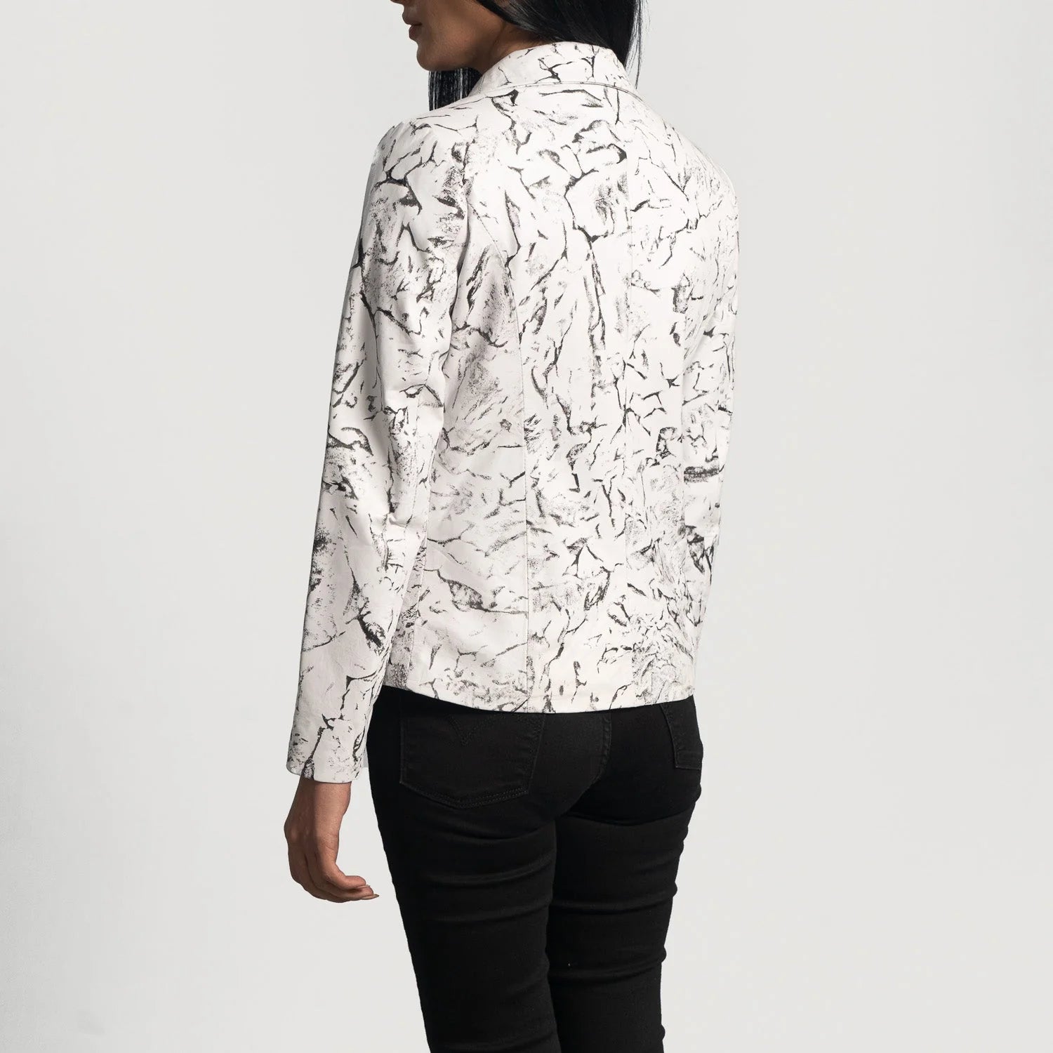 Back view of a woman wearing Donna Blake White Leather Blazer with black marble print and black pants