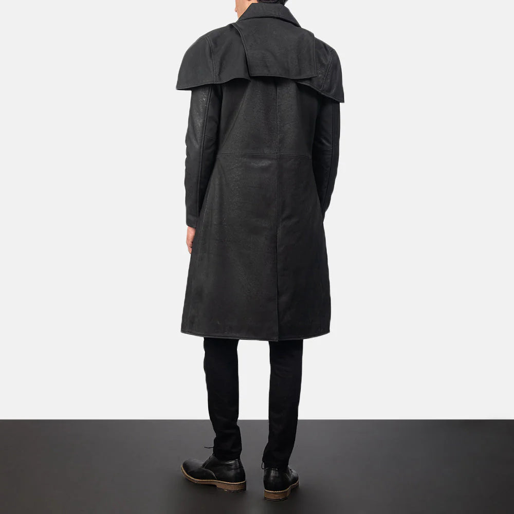 Back view of men's vintage leather long coat in black worn by a standing male model with black pants and shoes