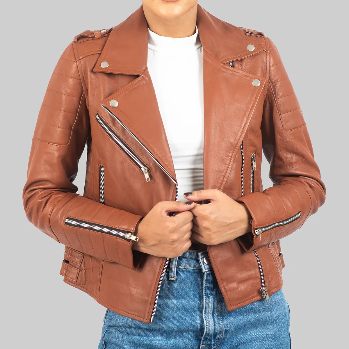 Lush Gear women's brown leather biker jacket with silver zippers and quilted sleeves styled with white top and blue jeans